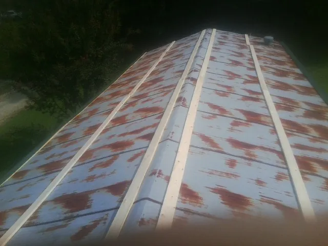 Rusted metal roof panels with new wood purlins before replacement — Storm Damage Roof Repair in Morriston by Roofing Brothers