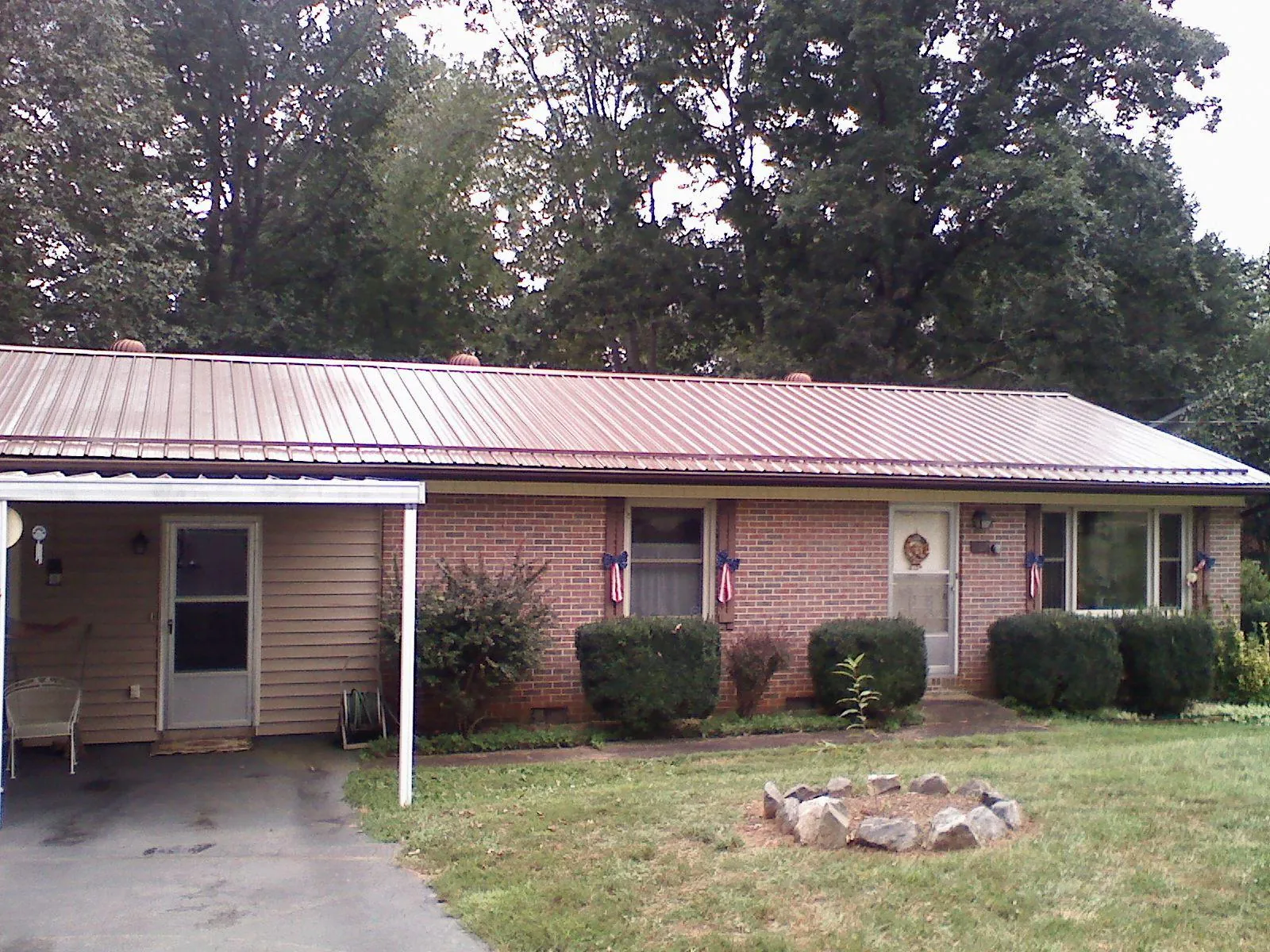 Bronze metal roof and carport on a brick ranch home — Roof Repair work by our crew in Morriston